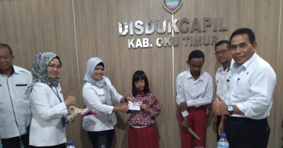 Plt. Sekdin Dukcapil OKU Timur, Endang Wahyuni, S.IP memberikan KIA kepada siswa SLB.